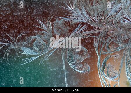 Jack Frost incisioni sulla finestra, con uno sfondo colorato. Foto Stock