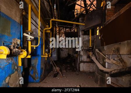 All'interno di un vecchio edificio industriale crollato. Vecchia pipeline arrugginita Foto Stock