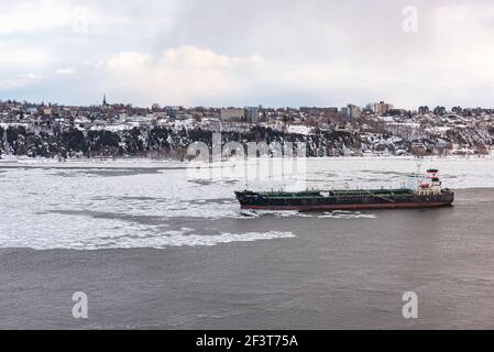 Quebec City, Quebec, Canada – 14 Mars 2021 : al tramonto, vista invernale del traffico marittimo sul fiume San Lorenzo di fronte alla città di Quebec. Foto Stock