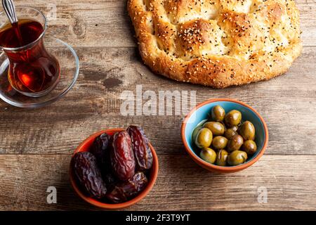 Vista angolata del pasto tradizionale per iftar e sahur nel mese sacro del Ramadan. Tè turco in bicchieri speciali, ramazan pidesi, un tipo di appartamento Foto Stock