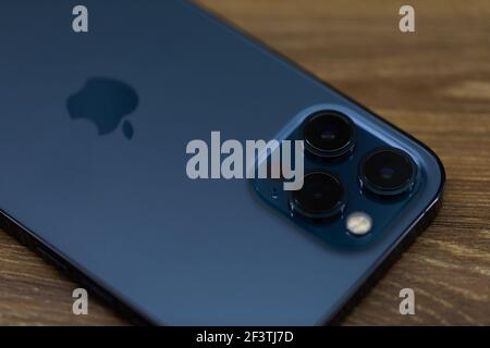 Chernivtsi, Ucraina - marzo.2021: Apple iphone 12 Pro Max smartphone blu su un tavolo di legno bianco in ufficio Foto Stock