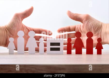 Uguaglianza tra diversità culturale con le mani dietro l'accoglienza di famiglie diverse rappresentato con taglio di famiglie di carta su tavola di legno e. isola Foto Stock