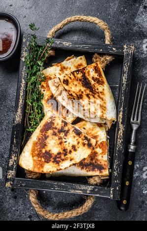 Quesadilla messicana con pollo, pomodoro, mais e formaggio. Sfondo nero. Vista dall'alto Foto Stock