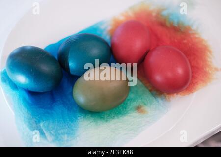 Uova sode con colorante rosso, verde e blu su carta da cucina in rotolo che si stesa ad asciugare Foto Stock