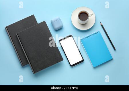 Composizione con libri e telefono cellulare su sfondo a colori Foto Stock