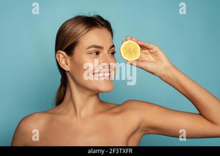 Bellissimo modello sorridente con trucco naturale, pelle facciale incandescente e agrumi. Foto Stock