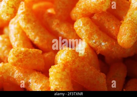 Primo piano di un mucchio di cheesies formaggio snack cibo. Foto Stock