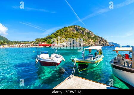 Piccole barche presso un molo nel porto di Palaiokastritsa spiaggia sull'isola egea di Corfù, Grecia. Foto Stock