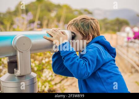 Binoscopio. Binocoli fissi della città. Un ragazzo guarda la città attraverso un binocolo Foto Stock