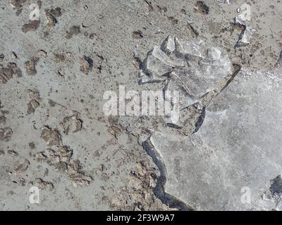 La struttura di cemento grigio pietra. Malta cementizia indurita primo piano. Piccole crepe sulla strada. Foto Stock