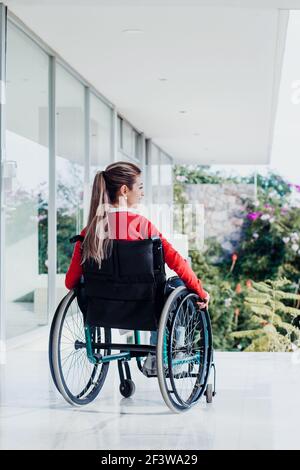 Giovane donna latina in sedia a rotelle sul posto di lavoro Foto Stock