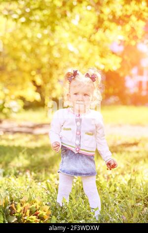 Bambina. Colori giallo autunno e verde. Natura cortile Foto Stock