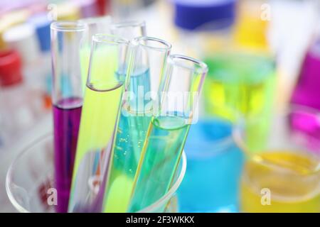 Provette per analisi chimiche con liquido multicolore su scrivania in laboratorio Foto Stock