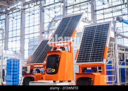 Pannelli solari fotovoltaici portatili automatici che lavorano alla fiera della tecnologia moderna. Sistema di inseguimento solare, fonte alternativa di elettricità, sostenitore Foto Stock