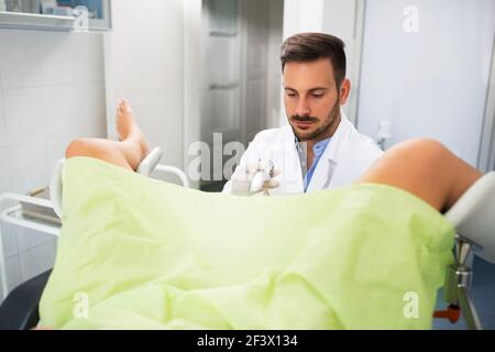 Bella giovane donna che si trova in clinica ginecologica facendo esame, ginecologo check up esame Foto Stock