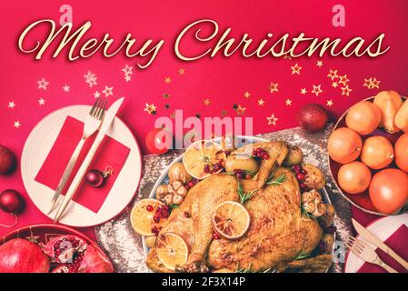 tacchino di Natale arrostito con fette d'arancia, mirtilli rossi, aglio con decorazione festiva, candele, mandarino, melograno, terrore d'oro, stella Foto Stock