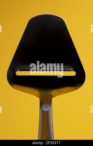Primo piano della silhouette della affettatrice per formaggi in acciaio inossidabile lucido riflettente. Foto Stock