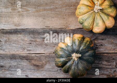 Zucca d'autunno biologica su sfondo di legno. Vista dall'alto. Spazio di copia. Fiera del raccolto di autunno. Giorno di ringraziamento. Autunno accogliente in oro. Foto Stock