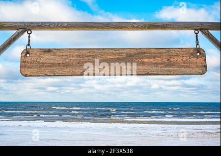 Cartello in legno con spazio copia su cielo blu e mare con sfondo onde. Cartello di legno vuoto. Foto Stock