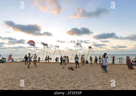 Turisti in visita alla famosa installazione sulla spiaggia con elefanti su bastoni, la spiaggia Sunset Sanato Beach Club Foto Stock