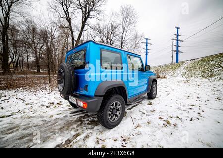 Mosca, Russia - 24 gennaio 2020: La prospettiva creativa del nuovo Suzuki Jimny mini SUV sul paesaggio della foresta invernale Foto Stock