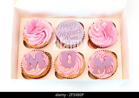 Una scatola di selezione della tazza del giorno della mamma torte sei in numero con giorno delle madri felici su una delle torte e MOM scritto su ciascuna delle torte. Foto Stock