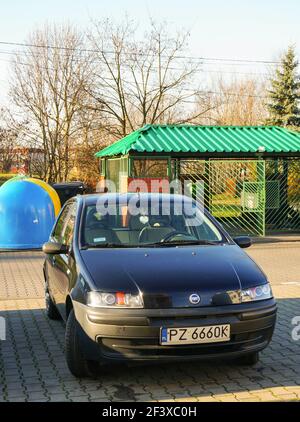 POZNAN, POLONIA - 12 dic 2015: Parcheggiata Fiat punto nera con contenitori per rifiuti sullo sfondo nell'area di stare Zegrze Foto Stock