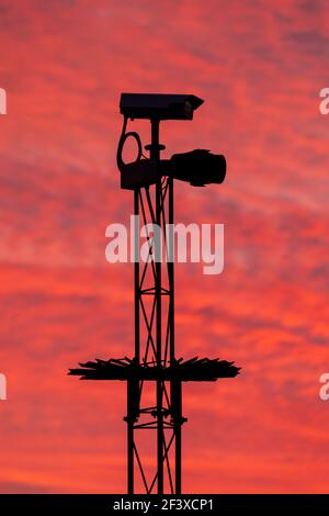Telecamera di sicurezza in silhouette contro un cielo rosa Foto Stock