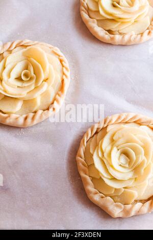 Tartette di mela grezza su carta da forno. Foto Stock