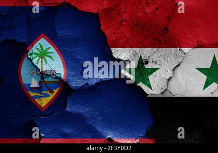 Bandiere di Guam e Siria dipinte su pareti incrinate Foto Stock
