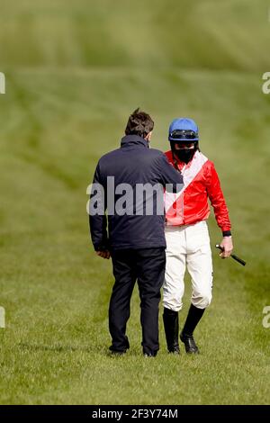 Jockey Jack Kennedy viene incontrato dall'allenatore Henry de Bromhead dopo essere caduto da envoi Allen durante il inseguimento dei Marsh Novices durante il terzo giorno del Cheltenham Festival all'ippodromo di Cheltenham. Data immagine: Giovedì 18 marzo 2021. Foto Stock