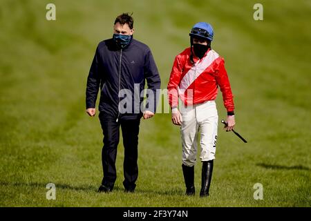 Jockey Jack Kennedy viene incontrato dall'allenatore Henry de Bromhead dopo essere caduto da envoi Allen durante il inseguimento dei Marsh Novices durante il terzo giorno del Cheltenham Festival all'ippodromo di Cheltenham. Data immagine: Giovedì 18 marzo 2021. Foto Stock