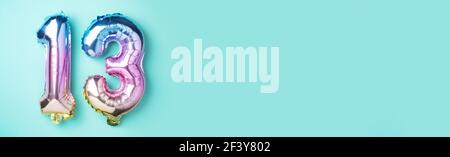 Layout creativo. Rainbow Foil numero di palloncino, cifra tredici. Biglietto d'auguri per compleanno con iscrizione 13. Concetto di anniversario. Vista dall'alto. Elegante Foto Stock