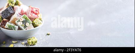 Dolci mediorientali su sfondo blu. Dessert arabo, baklava, halva, rahat lokum, sherbet, noci, pistacchi, datteri, uvetta, albicocche secche Foto Stock