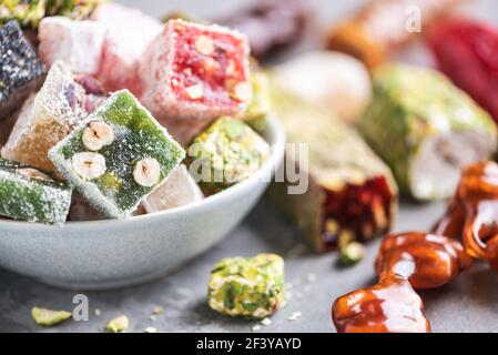 Dolci mediorientali su sfondo blu. Dessert arabo, baklava, halva, rahat lokum, sherbet, noci, pistacchi, datteri, uvetta, albicocche secche Foto Stock