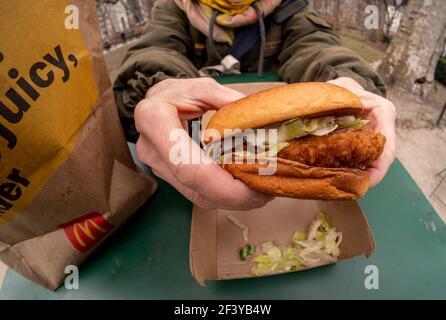 Un ristoratore si prepara a pranzo su un™€ McDonaldâ's Crisy Chicken Sandwich Deluxe mentre cena al fresco a New York mercoledì 17 marzo 2021. Nel 2019 Popeyeâ€™s ha debuttato il suo sandwich di pollo con grande successo, portando quasi ogni catena di fast food a generare un piatto di pollo croccante. McDonaldâ€™s è finalmente entrato come il gorilla 800-lb e ha già portato ad una spinta di traffico piede nei suoi ristoranti. (ÂPhoto di Richard B. Levine) Foto Stock