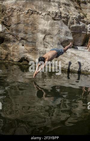 il giovane si tuffava nel piccolo lago nel deserto di negev Foto Stock