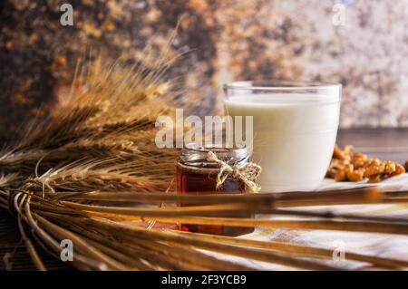 Miele in vaso con latte e noci. Concetto di colazione country. Сlose su Foto Stock
