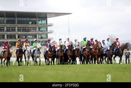 Corridori e piloti si riuniscono per l'inizio del Pertemps Network Final handicap hurdle durante il terzo giorno del Cheltenham Festival all'ippodromo di Cheltenham. Data immagine: Giovedì 18 marzo 2021. Foto Stock