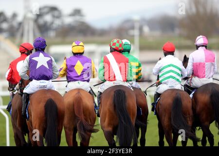 Corridori e piloti si riuniscono per l'inizio del Pertemps Network Final handicap hurdle durante il terzo giorno del Cheltenham Festival all'ippodromo di Cheltenham. Data immagine: Giovedì 18 marzo 2021. Foto Stock