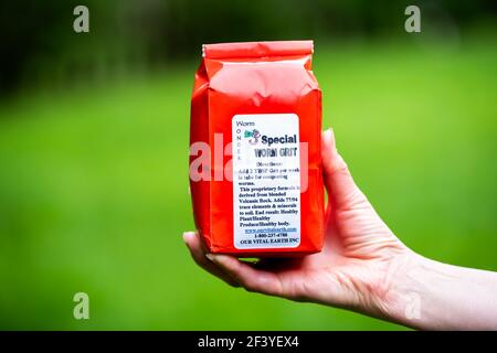 Herndon, USA - 29 aprile 2020: Donna che detiene speciale miscela di minerali in tracce di verme, polvere di roccia vulcanica per la digestione di vermi vivi e la colata sana Foto Stock