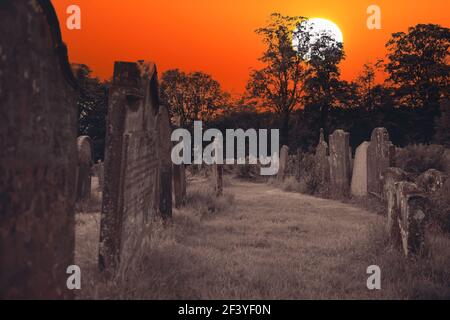 Pietre tombali molto vecchie nell'erba con cielo rosso e luna. Concetto Doomsday Foto Stock