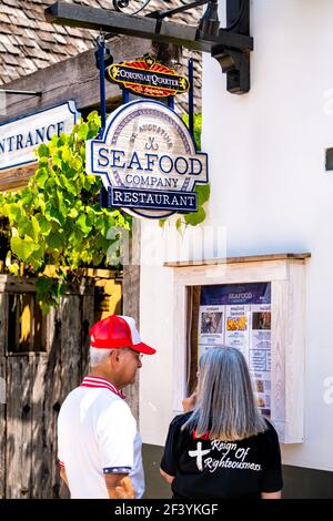 St. Augustine, Stati Uniti d'America - 10 maggio 2018: Persone anziane coppie in piedi fuori all'aperto lettura menu da Seafood Company segno ristorante in Florida città su S Foto Stock