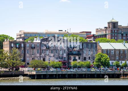 Savannah, Stati Uniti - 11 maggio 2018: Skyline della città dal lungomare della città vecchia di River Street con le persone che camminano nel quartiere dello shopping di ristoranti, caffè e. Foto Stock