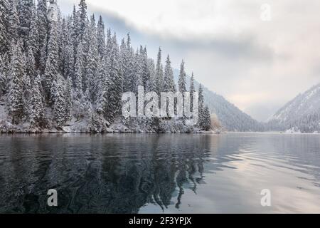 Lago di montagna dopo la nevicata. Il lago Kulsai, Kazakistan. Foto Stock