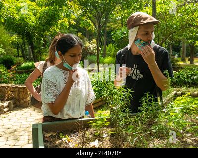 Medellin, Antioquia, Colombia - 6 gennaio 2021: Donna Latina con una maschera sotto la bocca accanto a un uomo caucasico Foto Stock