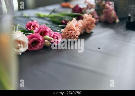Concetto di negozio di fiori. Primo piano bellissimo mazzo di fiori misti sul tavolo. Sfondo. Foto Stock