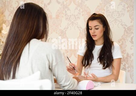 Estetista che applica la crema sulla mano di woman&rsquo;s usando il pennello. Cura delle mani, cura delle mani, concetto cosmetico. Foto Stock