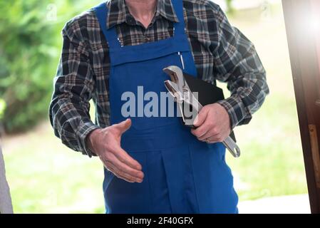 Riparatore in piedi all'ingresso di una casa Foto Stock