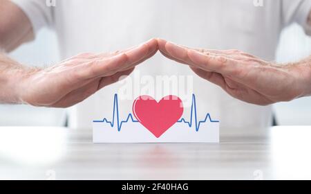 Simbolo heartbeat protetto dalle mani - concetto di assicurazione sanitaria Foto Stock